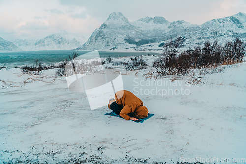 Image of A Muslim traveling through arctic cold regions while performing the Muslim prayer namaz during breaks