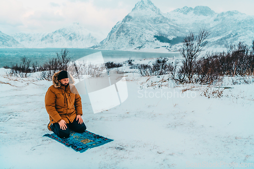 Image of A Muslim traveling through arctic cold regions while performing the Muslim prayer namaz during breaks