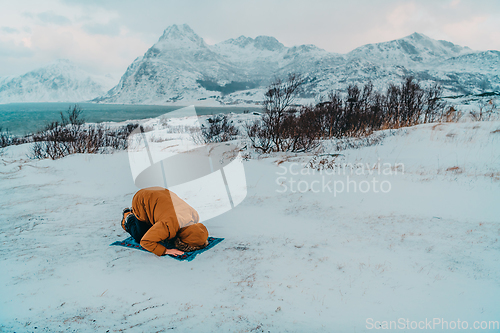 Image of A Muslim traveling through arctic cold regions while performing the Muslim prayer namaz during breaks
