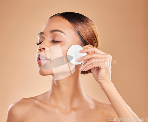 Image of Skincare, cotton and woman in studio for cleaning, wellness and toner on brown background. Face, beauty and girl model with facial pad for makeup removal, glowing skin or aesthetic while isolated