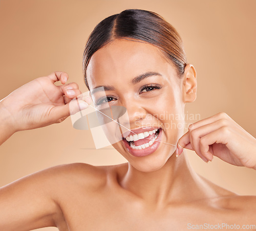 Image of Portrait, dental floss and woman in studio for oral hygiene, fresh and breath on brown background. Face, teeth and gum health by girl model flossing for tooth care, cleaning and cavity prevention