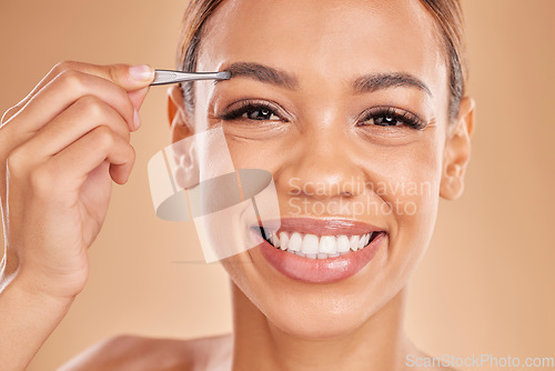 Image of Woman, face and tweezer on eyebrow for skincare beauty, grooming or trimming against a studio background. Portrait of happy female tweezing eyebrows with big smile for facial cleaning or hair removal