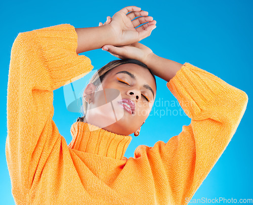 Image of Woman, makeup and fashion aesthetic of a young female with cosmetics in a studio. Posing, gen z and stylish person with youth and colorful eyeliner with isolated and blue background feeling cool