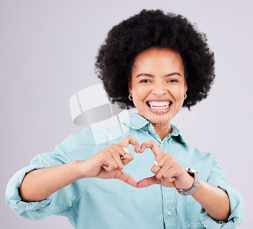 Image of Black woman, studio portrait and heart hands with afro, smile and romance icon with love, confidence and face. Happy african, model and emoji for happiness, date and romantic sign by gray background