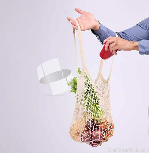 Image of Hand, shopping and bag for vegetables closeup in studio by background for diet, health or deal in recycle material. Grocery discount, fruit or vegetable for man, healthy food or sustainable lifestyle