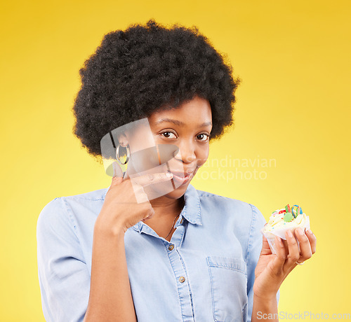 Image of Black woman, cupcake and studio portrait for smile, temptation or cheat with junk food by yellow background. African model, cake of diet choice for health, nutrition or sweets with decision for meal