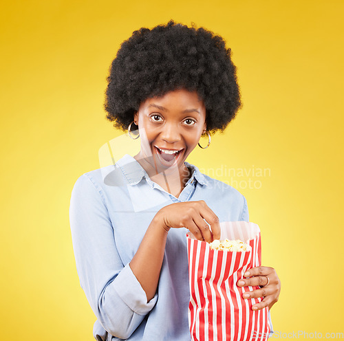 Image of Surprise, wow and popcorn with black woman in studio for movie, streaming service and cinema. Happy, comedy and theatre with female and snack isolated on yellow background for food, tv and film