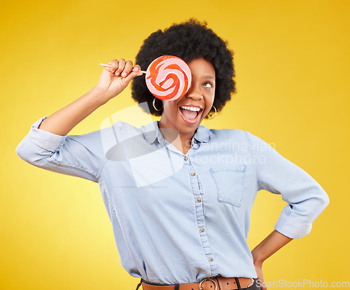 Image of Excited, candy and lollipop with black woman in studio for colorful, cheerful and positive. Young, happiness and dessert with female isolated on yellow background for treats, food and confectionary