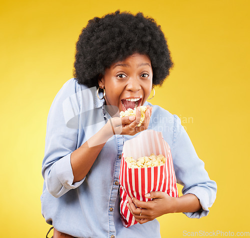 Image of Happy, food and popcorn with black woman in studio for movie, streaming service and cinema. Crazy, comedy and theatre with female and snack isolated on yellow background for eating, tv and film