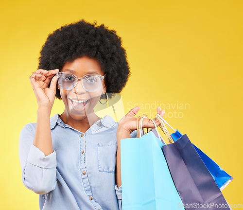 Image of Fashion, portrait and black woman with shopping bags, smile and excited for sale in studio on yellow background. Face, shopper and girl customer cheerful after boutique, retail or store discount