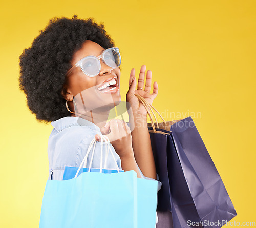 Image of Shopping bag, retail and happy black woman with sales product, discount fashion deal or mall store present. Commerce market, luxury designer gift or chic studio customer isolated on yellow background
