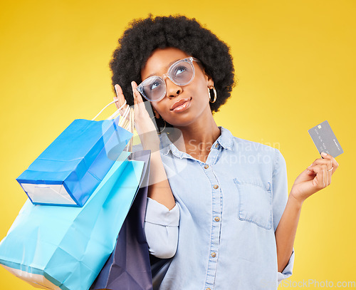 Image of Shopping bag, retail thinking or black woman with credit card for sales product, fashion deal or mall store present. Commerce market, gift idea or customer contemplating isolated on yellow background