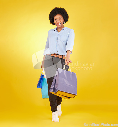 Image of Black woman with shopping bag, portrait with fashion and retail, smile on yellow studio background. Happiness, female with discount and sale at boutique with designer brand, happy and mockup space