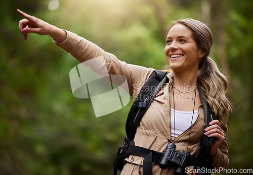 Image of Happy hiker pointing or woman in hiking nature, forest or wilderness for a trekking adventure. Freedom, backpack or healthy female walking in natural park or woods for exercise or wellness on holiday