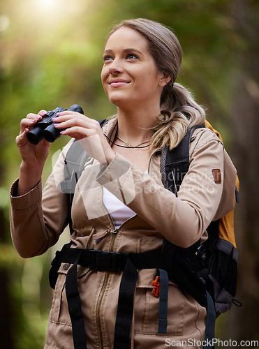 Image of Binocular, forest and hiking happy woman in travel journey, jungle adventure or nature explore with backpack gear. Fitness hiker or camper person trekking in woods and search or birdwatching outdoor