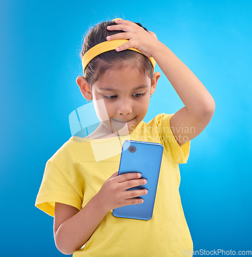 Image of Phone, stress and child worry on blue background with mistake, accident and guilty expression in studio. Technology, smartphone and young girl with anxiety, stressed out and worried for trouble