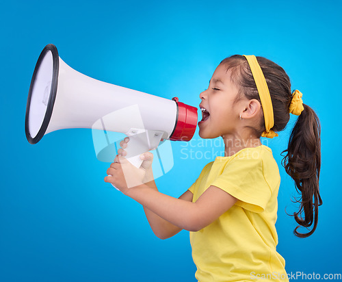 Image of Communication, shout and child with megaphone for news, opinion and announcement on blue background. Talking, speaking mockup and young girl with loudspeaker for voice, scream and attention in studio