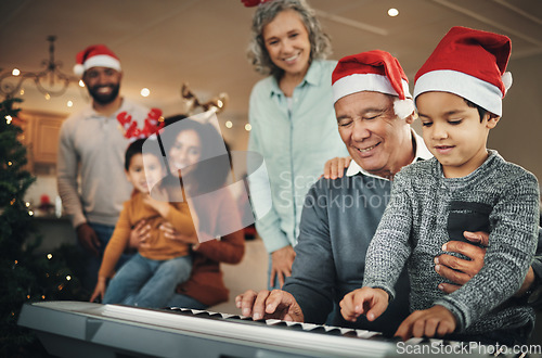 Image of Piano, christmas and elderly man with grandson in a living room, happy and celebration while bonding in their home. Family, music and retired senior man with boy, festive and learning instrument