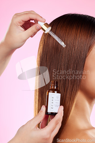 Image of Closeup, woman and hair care with oil, pipette and luxury salon treatment against a studio background. Zoom, female and lady with scalp product, volume and wellness for shine, growth and grooming