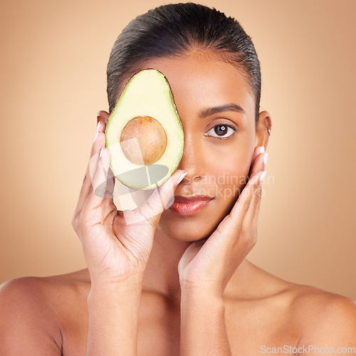 Image of Woman, beauty and face with avocado and natural skincare in portrait, facial and makeup on studio background. Vegan, cosmetic care and product from nature, organic and female with hands and glow