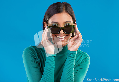 Image of Sunglasses, fashion and woman with cool style and smile feeling happy and excited isolated in studio blue background. Portrait, young and model or trendy gen z female with stylish beauty