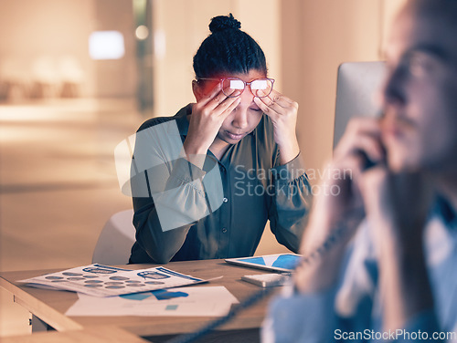 Image of Business woman, headache and computer in stress, burnout or suffering pain at night by office desk. Female employee rubbing head or touching painful area by desktop PC feeling overworked at workplace