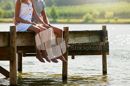 Image of Couple together in nature, relax by lake and summer, travel and adventure, love and care outdoor. People in relationship, trust and bonding on vacation, man and woman sitting on jetty with freedom