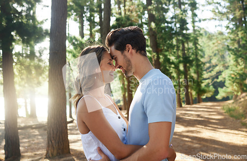 Image of Hug, happy and an affectionate couple in nature for peace, relaxation and date in the forest. Smile, embrace and a young man and woman hugging for love, care and affection on a vacation in the woods