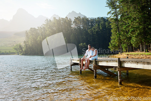 Image of Love, relax and pier with couple at lake for bonding, romance and affectionate date. Nature, travel and holiday with man and woman cuddling on boardwalk in countryside for happy, summer and vacation