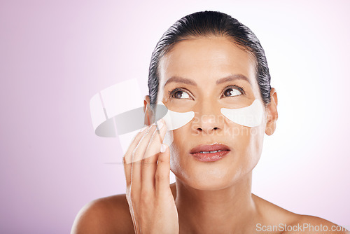 Image of Face, skincare and woman eye patches in studio isolated on a purple background. Thinking, dermatology and serious female model with facial mask or cosmetics pads for healthy skin, collagen and beauty