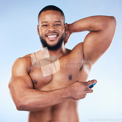 Image of Deodorant, portrait and black man with smile in studio for beauty, grooming and body hygiene on blue background. Skincare, health and male spraying aerosol, fragrance and scent product for underarm