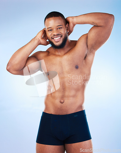 Image of Black man, fitness and body, smile in portrait and abs, healthy and flex arms, muscle and strong on blue background. Shirtless male in underwear, exercise and bodybuilder with bare abdomen in studio