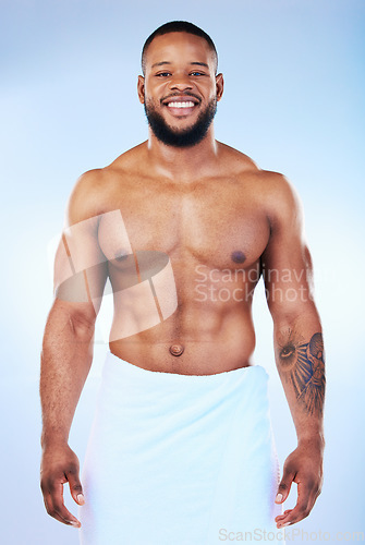 Image of African man, shower and towel in studio portrait with smile, wellness and start to morning by blue background. Young guy, cleaning body and skincare for happiness, health and self care by backdrop