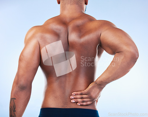 Image of Black man, back pain and injury with fitness and health, medical problem and aching body in studio. Emergency, muscle tension and male athlete with joint ache from workout on blue background