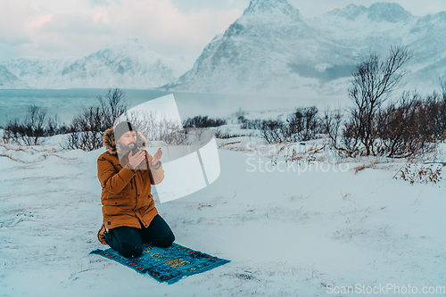 Image of A Muslim traveling through arctic cold regions while performing the Muslim prayer namaz during breaks