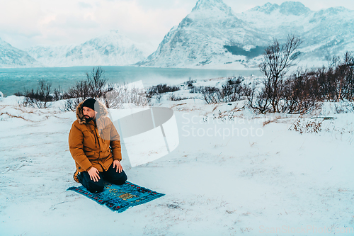 Image of A Muslim traveling through arctic cold regions while performing the Muslim prayer namaz during breaks