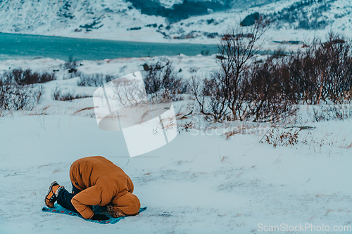 Image of A Muslim traveling through arctic cold regions while performing the Muslim prayer namaz during breaks