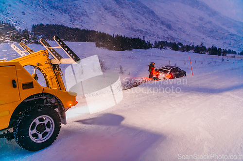Image of The roadside assistance service pulling the car out of the canal. An incident on a frozen Scandinavian road.