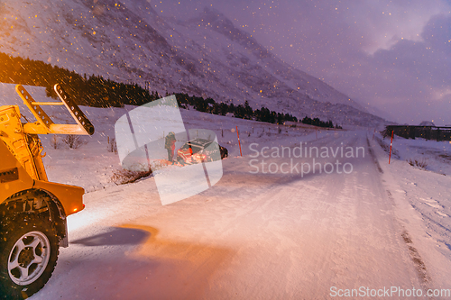 Image of The roadside assistance service pulling the car out of the canal. An incident on a frozen Scandinavian road.