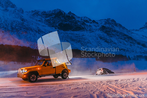 Image of The roadside assistance service pulling the car out of the canal. An incident on a frozen Scandinavian road.