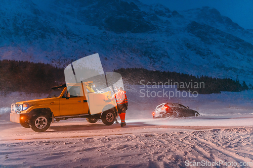 Image of The roadside assistance service pulling the car out of the canal. An incident on a frozen Scandinavian road.