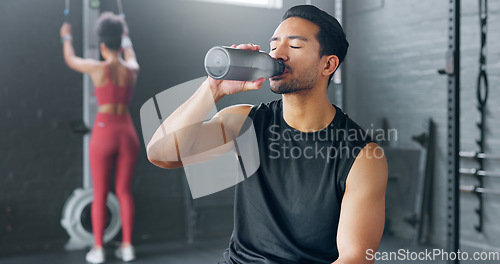 Image of Man, tired and drinking water in gym workout, training and exercise break for energy recovery and muscle rest. Personal trainer, fitness coach and drink for wellness, sports health and weight loss