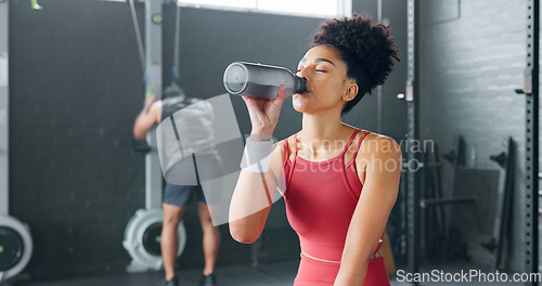 Image of Black woman, rest and drinking water with bottle for fitness, wellness and health in gym. Young female, athlete or healthy lady relax, being thirsty after practice or training for exercise or workout