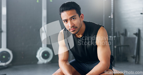 Image of Gym, sports man and fitness training by man serious about health, wellness and competitive mindset. Face, portrait and asian instructor sitting before workout, exercise and cardio exercises in Japan
