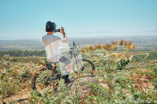 Image of Cycling, fitness and man on a bicycle with phone for picture, photography or photo in nature. Cyclist, workout and social media health influencer live streaming for blog, website or profile picture