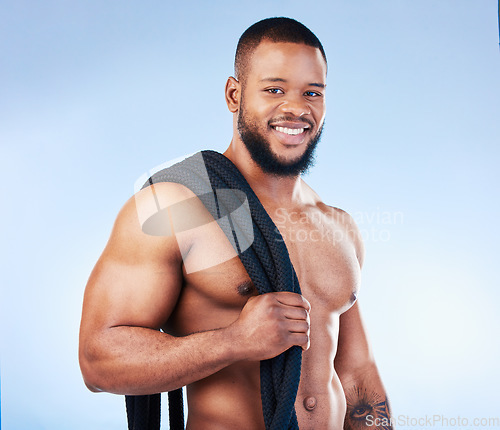 Image of Fitness, man and portrait smile with rope for intense workout, exercise or training against blue studio background. Happy face and fit muscular male model holding thick ropes for exercising on mockup
