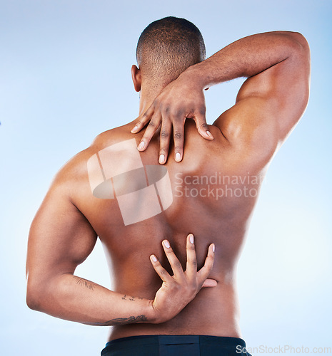 Image of Back, strong and black man with muscle touching his spine as self love, skincare and isolated in a studio blue background. Health, wellness and strong muscular male model embracing skin