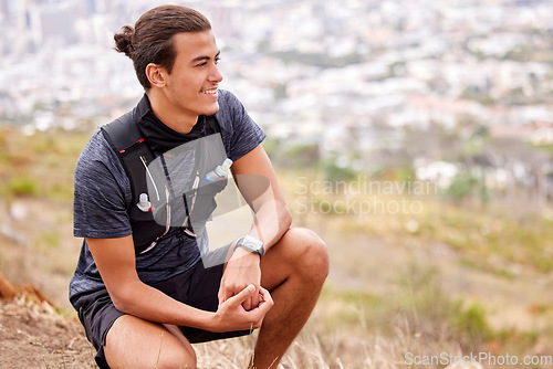 Image of Hiking, fitness and man thinking and rest on a mountain after trekking as morning exercise, health and workout routine. Relax, break and happy young athlete or male smile on a hill in nature