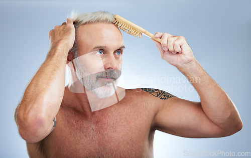 Image of Mature man, brush hair and scalp treatment in a studio with a male model doing beauty routine. Wellness lifestyle, hairstyle care and barber and hairdresser comb with an isolated grey background