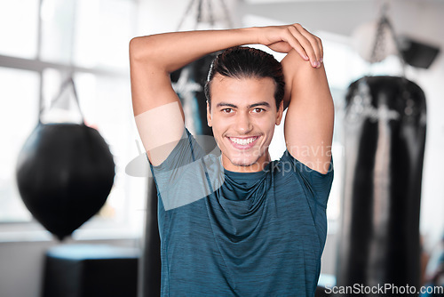 Image of Portrait, stretching arm and man in gym ready to start workout, training or exercise. Sports smile, health fitness and happy male athlete warm up, stretch or prepare for exercising for flexibility.